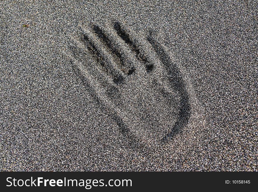 Hand print in black sand with crashed seashells. Seltjarnarnes beach, Iceland. Hand print in black sand with crashed seashells. Seltjarnarnes beach, Iceland.