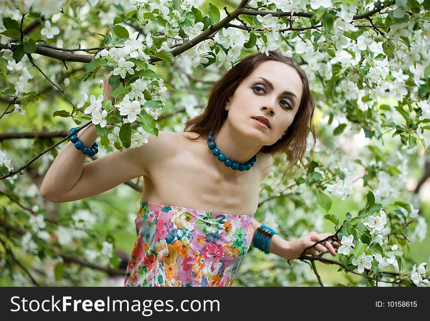 Tender girl in the garden with flowerings trees