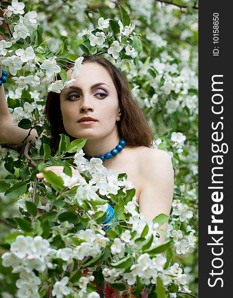 Tender girl in the garden with flowerings trees