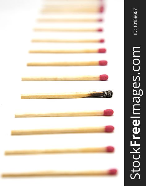 A simple row of red head matches with one single burnt out match in focus. A simple row of red head matches with one single burnt out match in focus