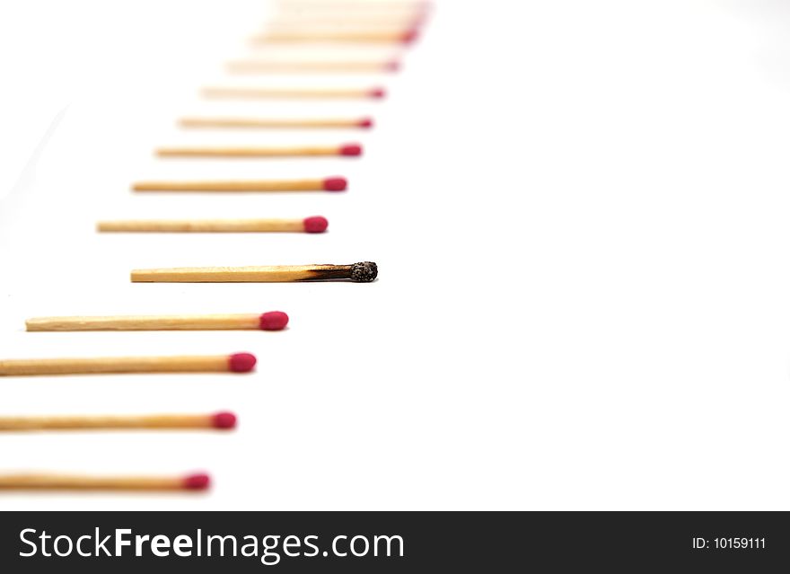 A simple row of red head matches with one single burnt out match in focus. A simple row of red head matches with one single burnt out match in focus