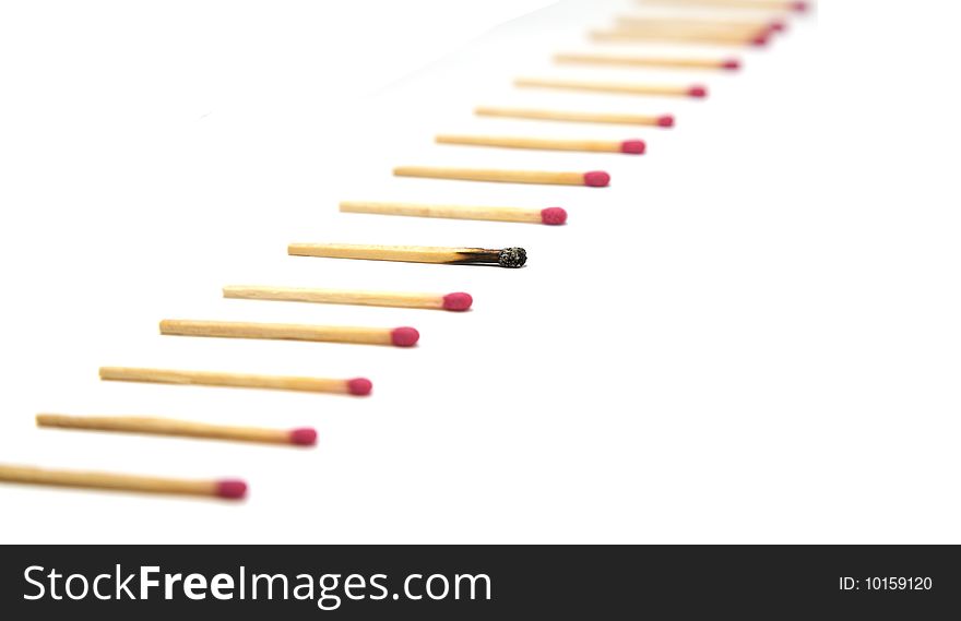 A simple row of red head matches with one single burnt out match in focus. A simple row of red head matches with one single burnt out match in focus