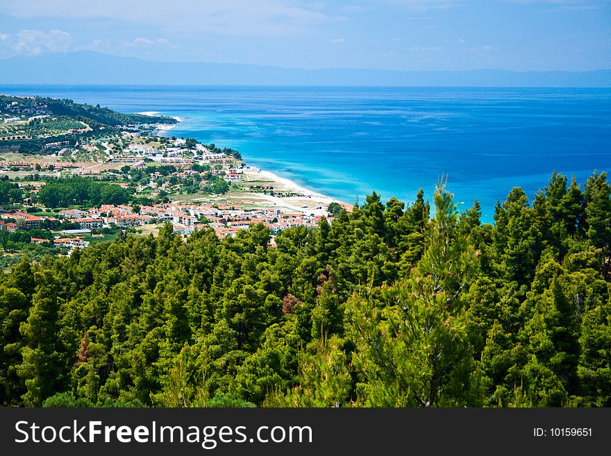 Marine landscape. Greece, Kassandra. Blue sea and sky, small towns with red roofs.