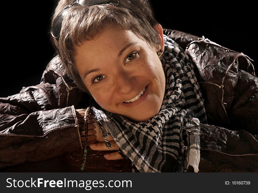 Beauty woman in leather jacket over a black background