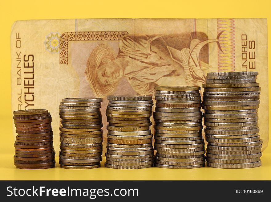 Foreign Coins And Notes On A Yellow Background