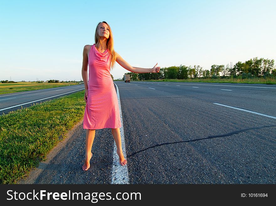 The woman running on road against the sunset sun