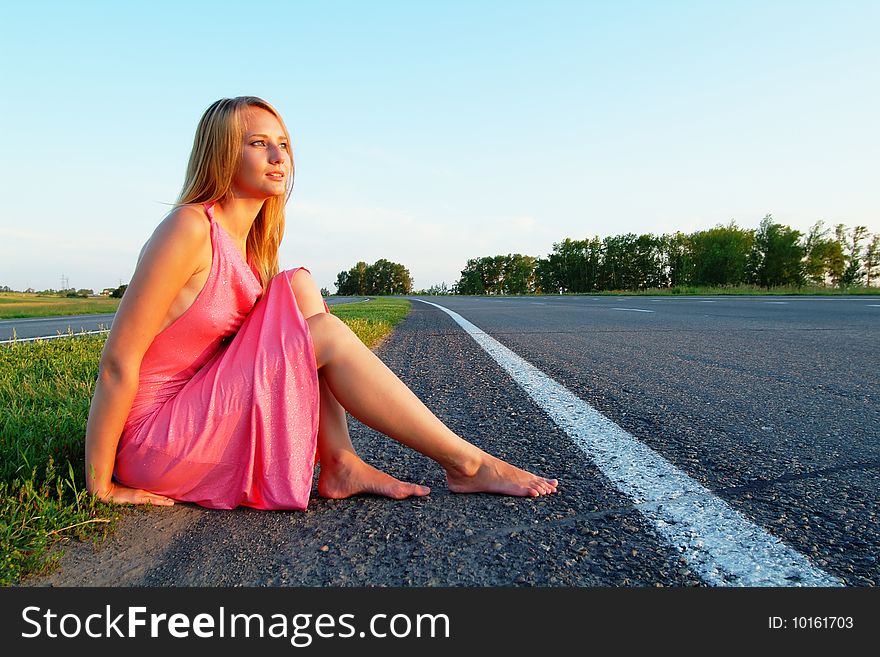 The woman running on road against the sunset sun