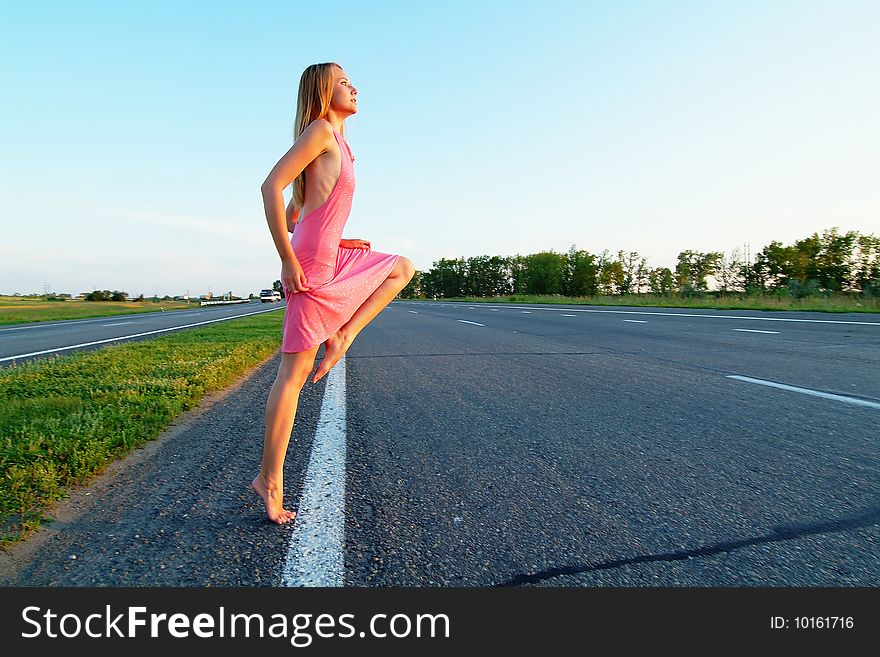 The woman running on road against the sunset sun