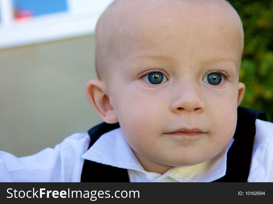 An deep thinking little boy with big blue eyes and and bald head