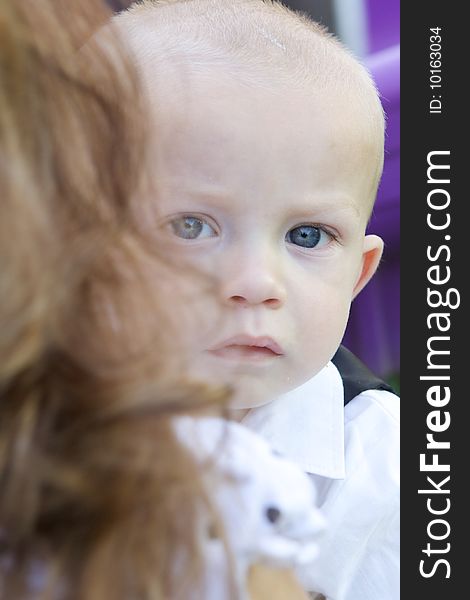 An interested little boy with big blue eyes and a bald head