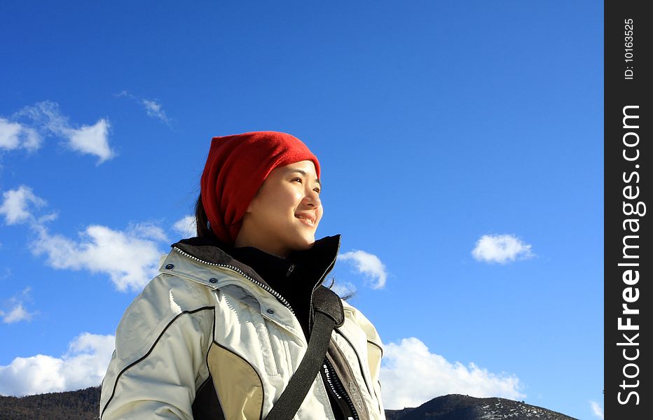 Woman hiker stands and enjoying the sunshine.