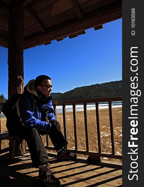 Hiker sitting near the lake and enjoying the sunshine.