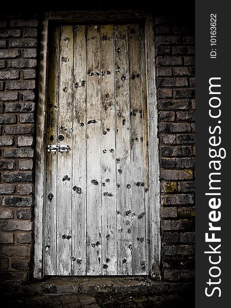 A locked wood door in brick wall. A locked wood door in brick wall