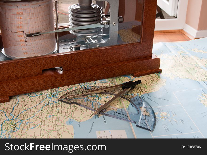 Barograph in a wooden box standing on a map. Barograph in a wooden box standing on a map