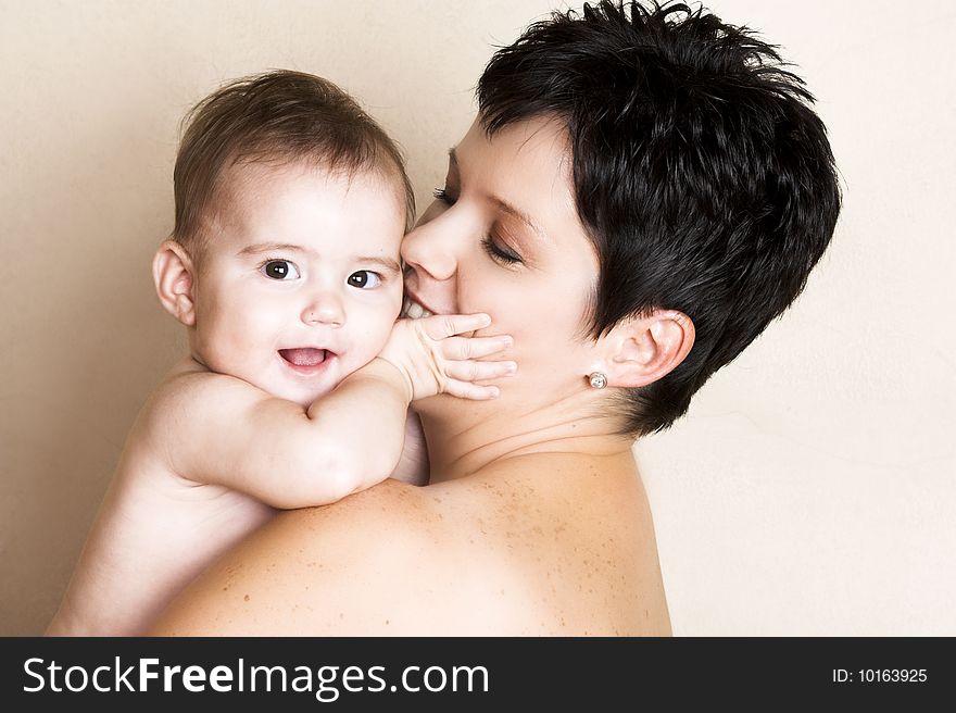 Beautiful brunette mother holding her cute baby. Beautiful brunette mother holding her cute baby