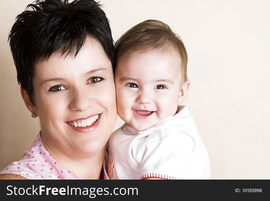 Beautiful brunette mother holding her cute baby. Beautiful brunette mother holding her cute baby