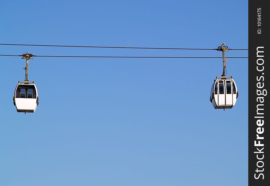 Two cable car cabins set against a blus sky, lisbon, portugal. Two cable car cabins set against a blus sky, lisbon, portugal