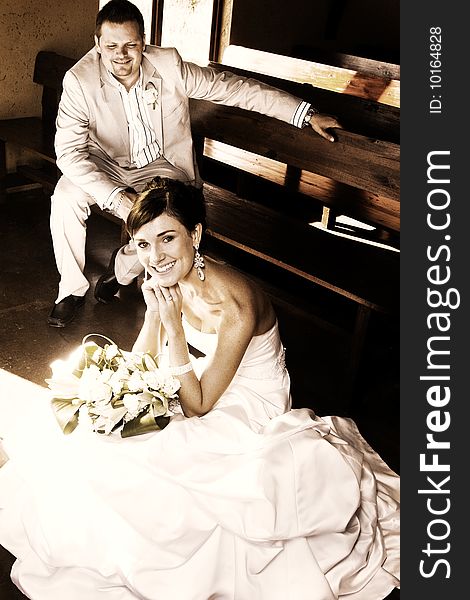 Beautiful brunette bride sitting by her groom in the chapel. Beautiful brunette bride sitting by her groom in the chapel