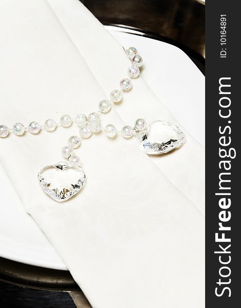 Bridal necklace with hearts and pearls on a stand