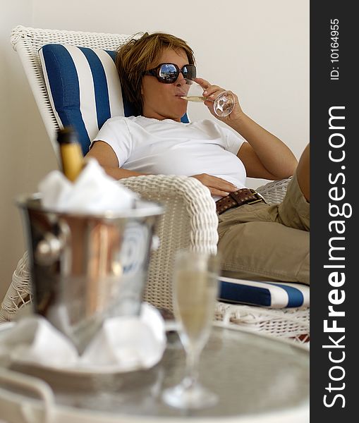 Woman relaxing on a terrasse while drinking Champagne. Woman relaxing on a terrasse while drinking Champagne