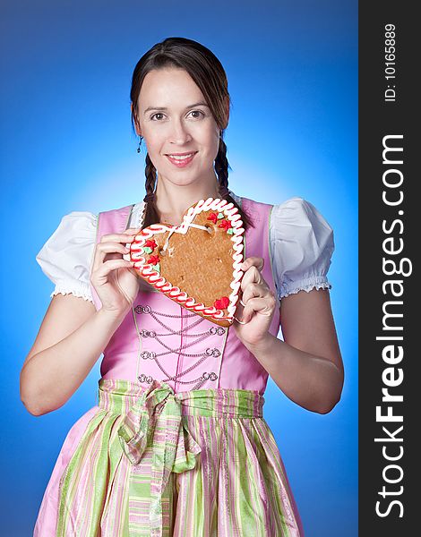 A young Oktoberfest girl in a Dirndl and a traditional gingerbread Herzl. A young Oktoberfest girl in a Dirndl and a traditional gingerbread Herzl.