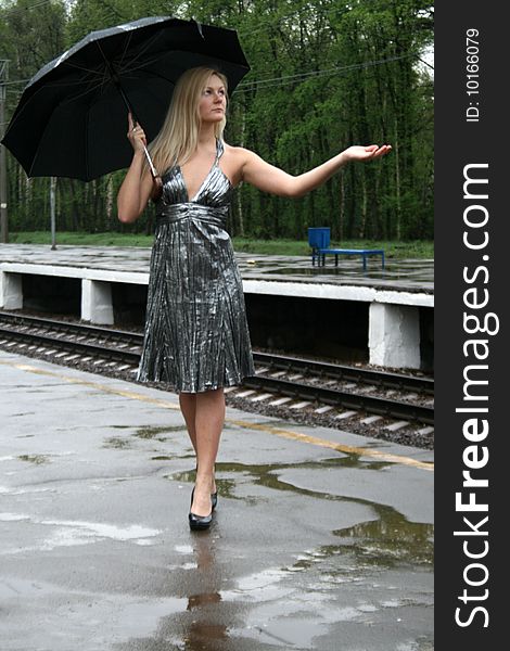 Girl with an umbrella walking on platform
