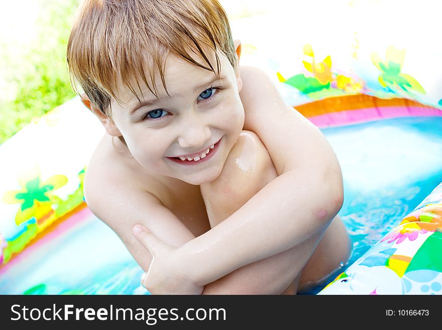 The boy bathes in inflatable pool