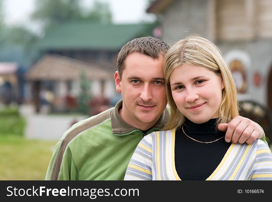 Young Couple Standing With Rural Background