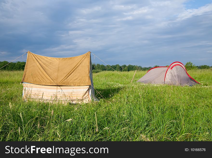 Two tourist tents on medow against nature