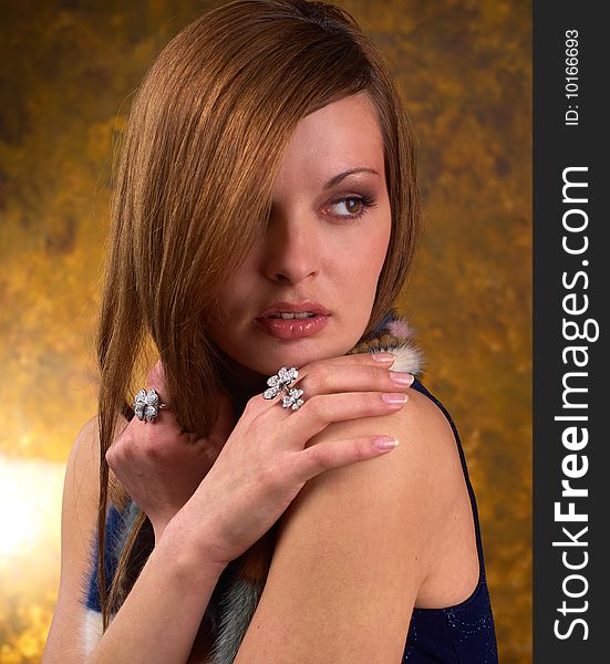 Portrait of a young beautiful brunettes, with rings on the fingers and the fur cape blue. Portrait of a young beautiful brunettes, with rings on the fingers and the fur cape blue