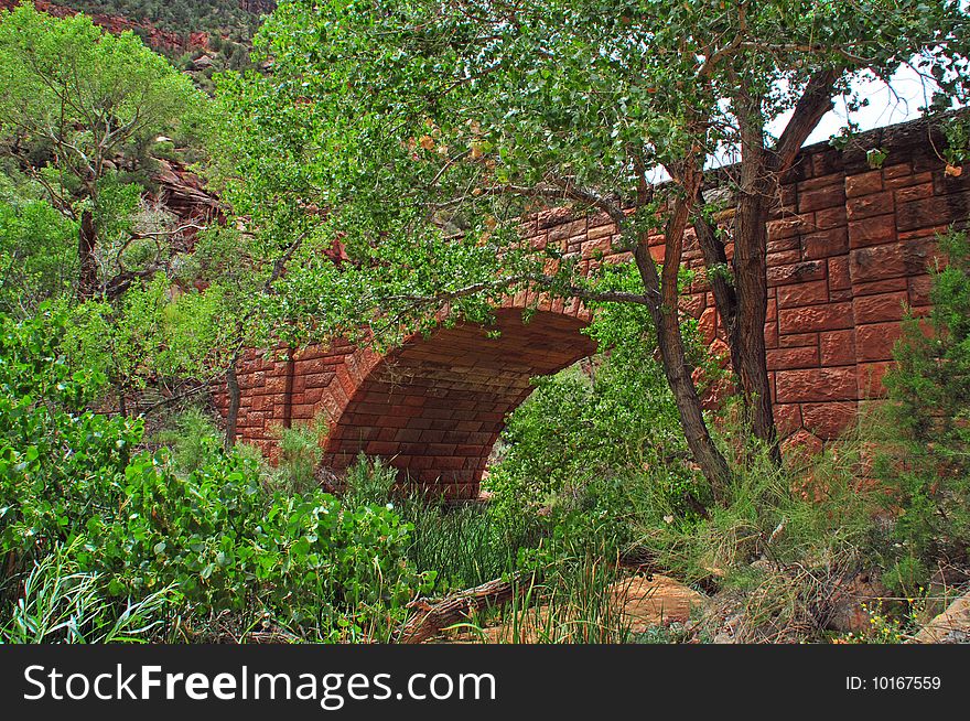 Red brick bridge hidden behind trees. Red brick bridge hidden behind trees