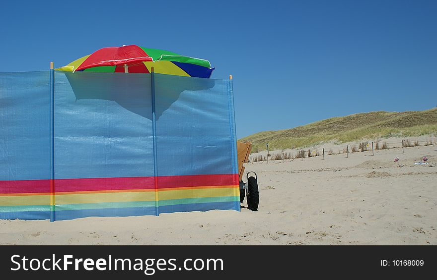 Windscreen, umbrella and cart on the beach. Windscreen, umbrella and cart on the beach