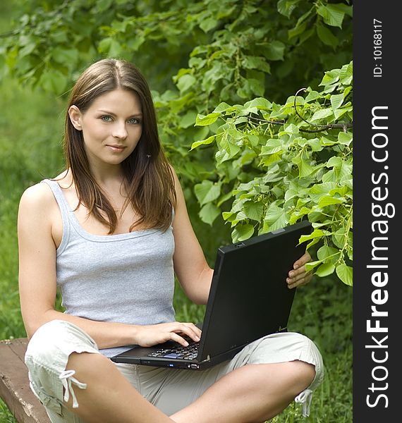 Girl with laptop relaxing on the grass