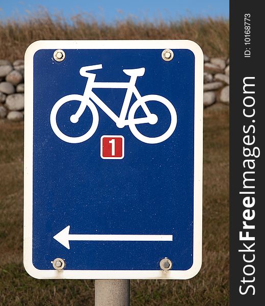 Blue Sign with Bicycle and Stonefence in Background. Blue Sign with Bicycle and Stonefence in Background