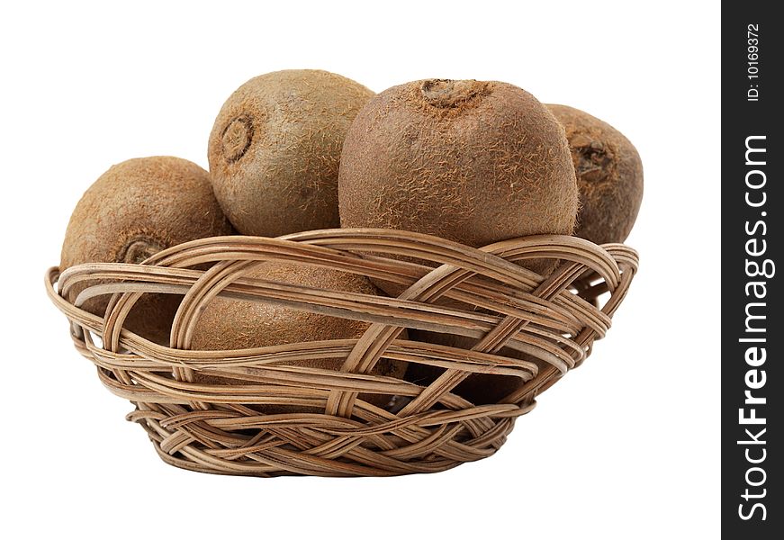 Color photo of kiwi fruit in a wicker basket against the backdrop of bananas and oranges