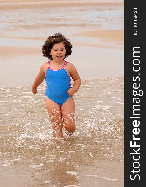 Cute little girl on the beach playing