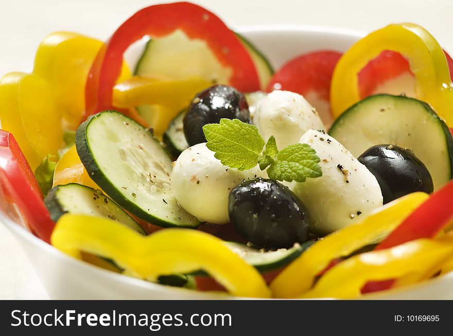 Greek salad with black olives, pepper, cucumber and mozzarella close up