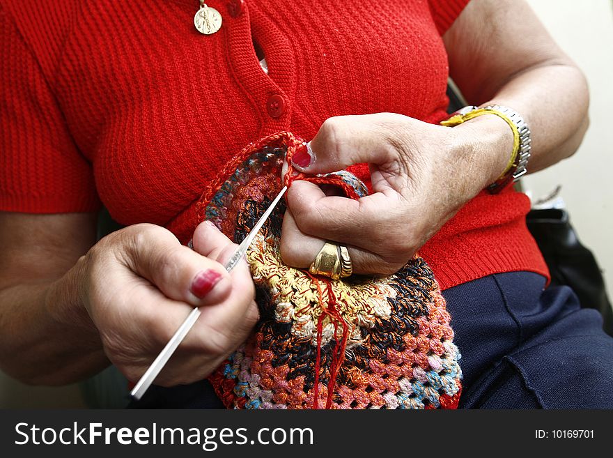 Senior woman's hands knitting a scarf