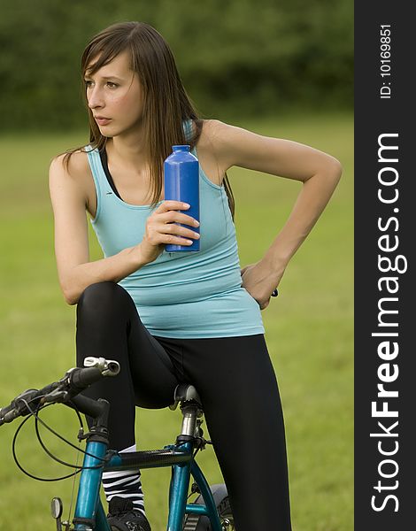 Active woman on bike with bottle of water. Active woman on bike with bottle of water