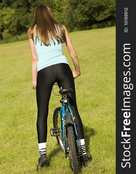 Active woman biking outdoor, shot from back