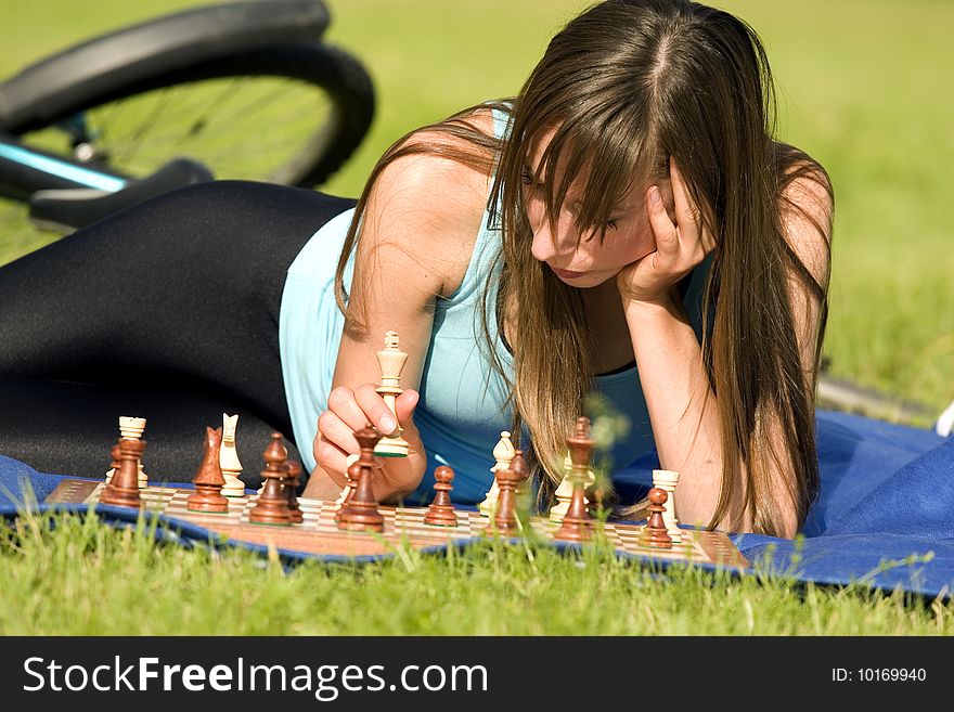 Fitness woman playing chess outdoor