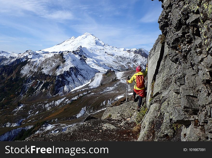 A hiker looking at a snowcapped mountain peak. A hiker looking at a snowcapped mountain peak.