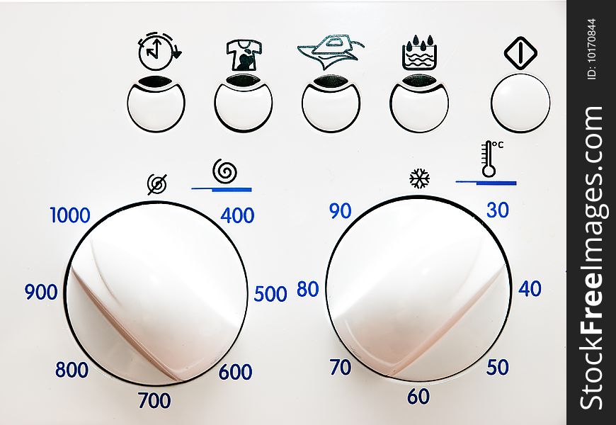 Detail of a white washing machine, showing program selection dial and drying options. Detail of a white washing machine, showing program selection dial and drying options.