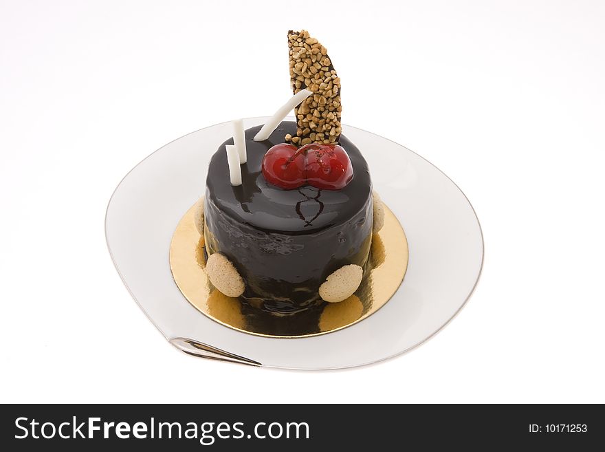 Chocolate cake with two cherries on a white plate