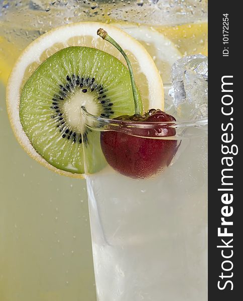 Red cherry, kiwi and lemon slice garnish on glass of ice cold lemonade. Red cherry, kiwi and lemon slice garnish on glass of ice cold lemonade