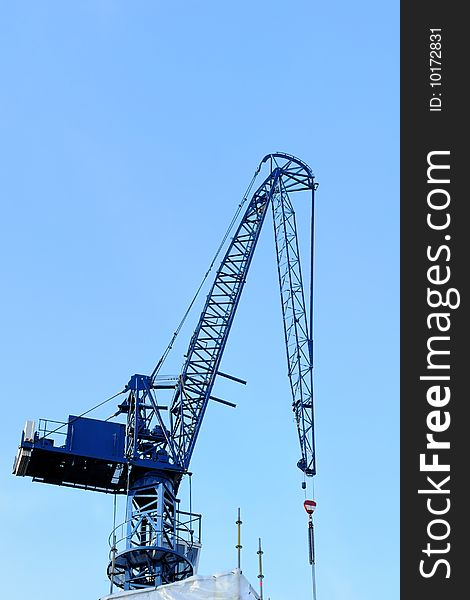 Blue construction crane with blue sky on background