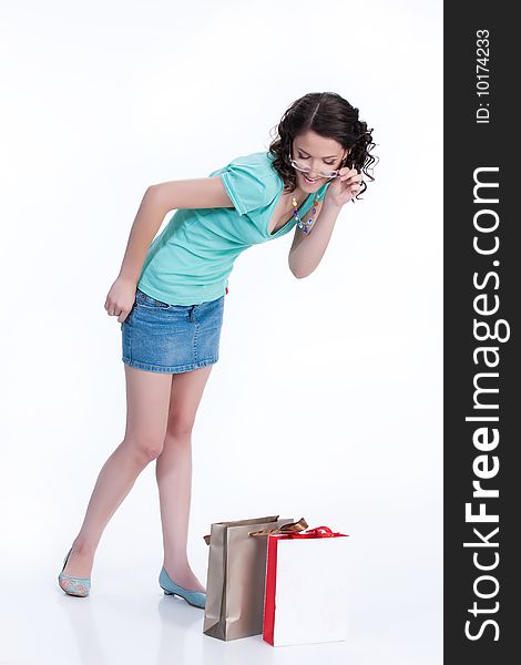 Young woman looking at the shopping paper bags. Young woman looking at the shopping paper bags