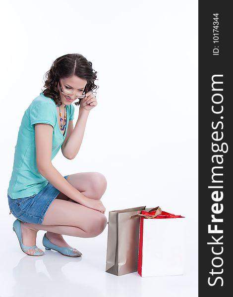 Young woman looking at the shopping paper bag. Young woman looking at the shopping paper bag