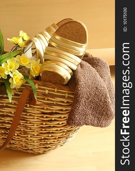 Beach bag with female summer footwear, towel and yellow flowers