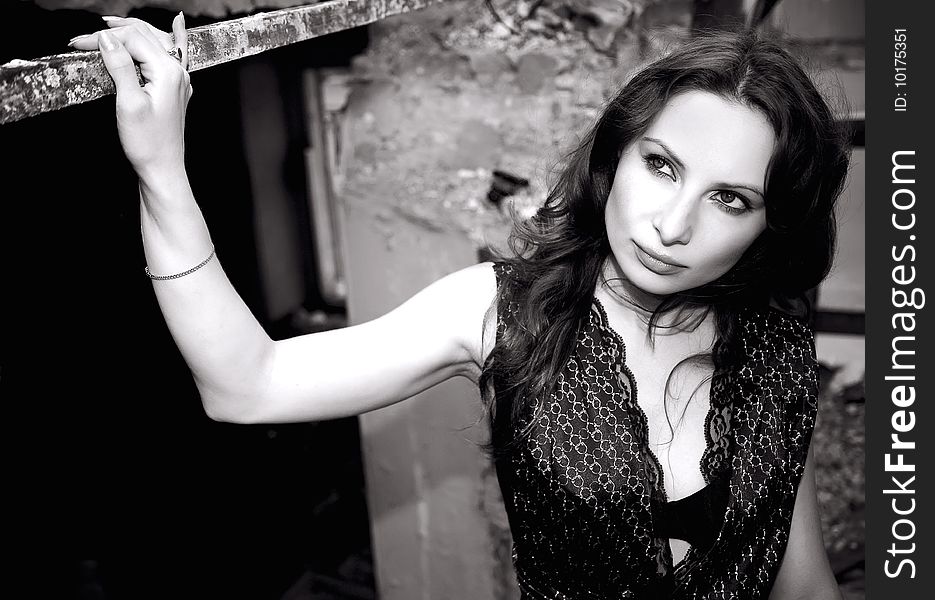 Pretty charming woman in ruins in elegant dress in monochrome